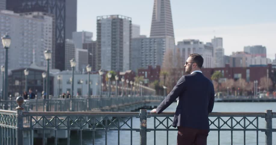 A man stands on a city pier