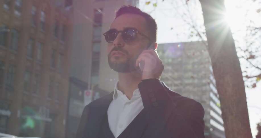 A man answers his phone outside in the city