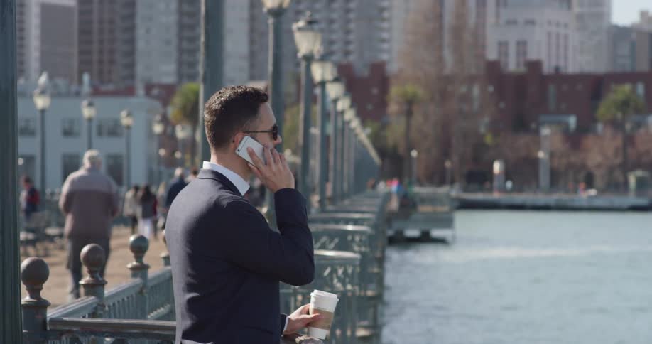 A man in a suit uses his phone outside