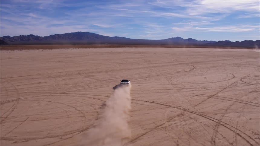 A car drives across the open land