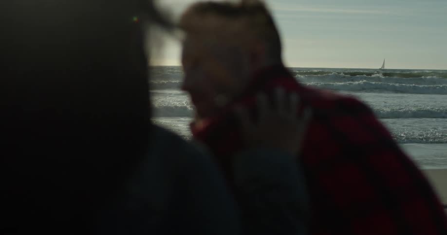A woman and man stand together on the beach