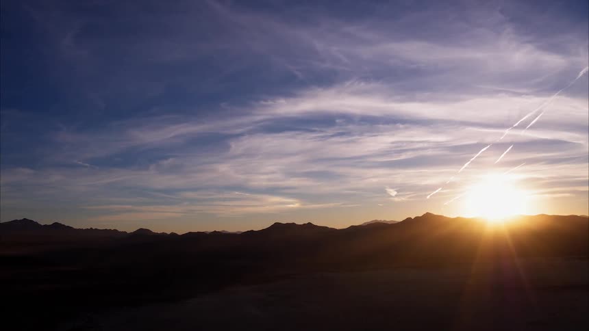 The sun sets over mountains
