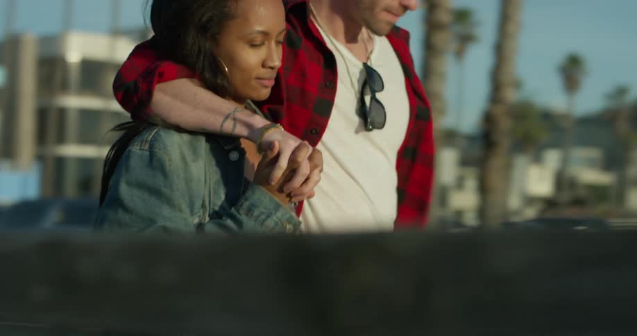 A man kisses a woman as they walk together