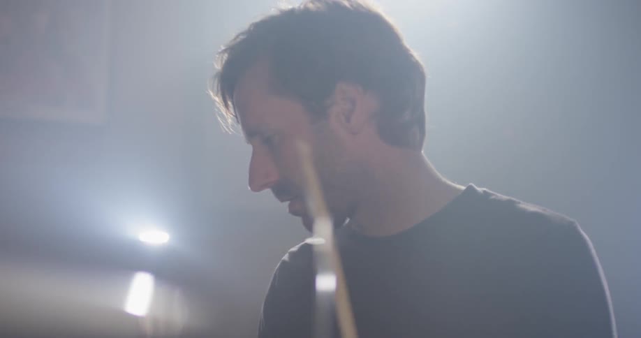A man plays drums with drumsticks