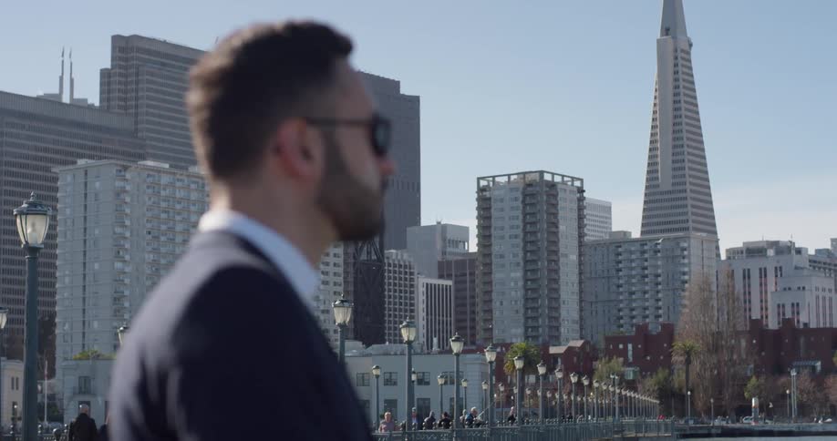 A man in a suit stands out on the city pier