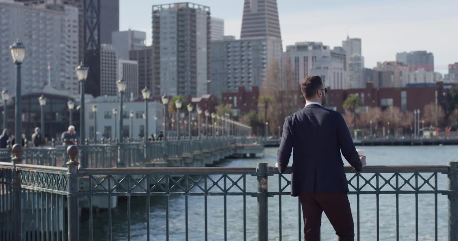 A man stands on a city pier