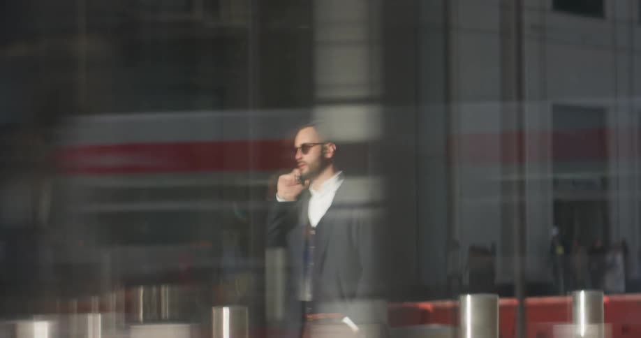 A man in a suit uses his phone outside