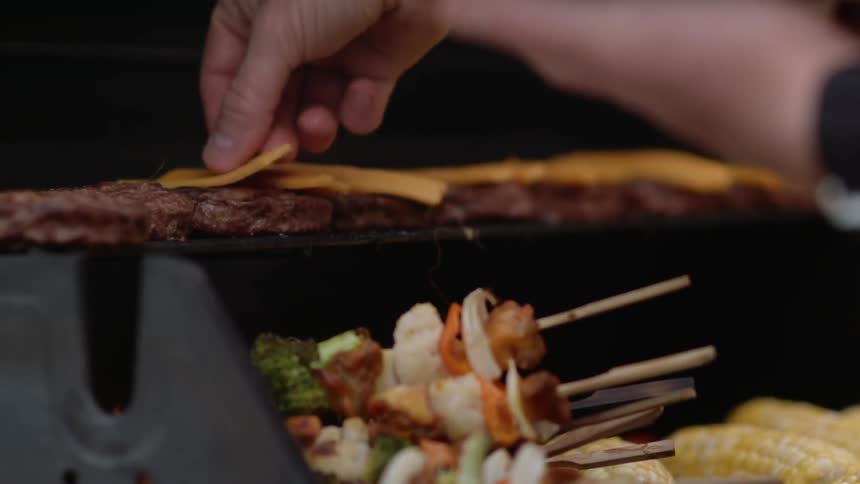 Burgers and kabobs are being prepared on a grill