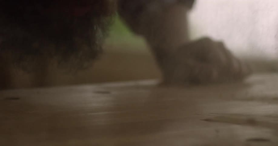 A man blows sawdust away from a table