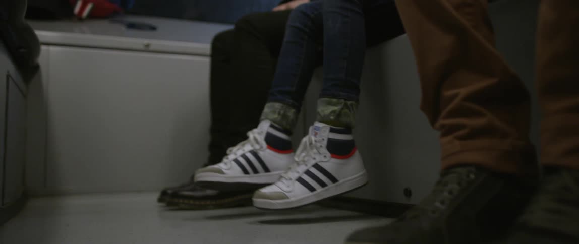 A child's feet dangle while riding public transportation