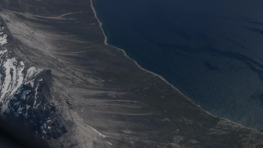 Coast line near a snow capped mountain on a clear day