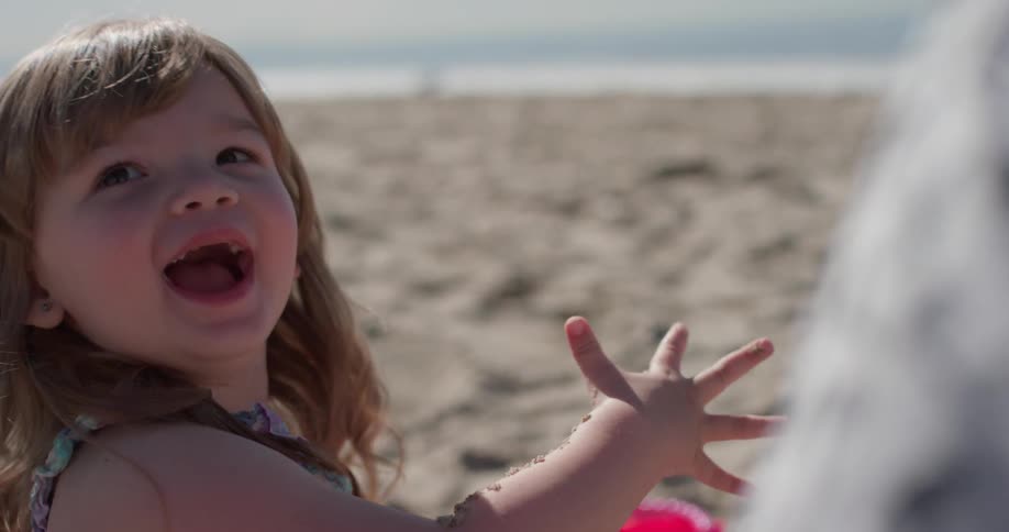 A young girl plays on the beach