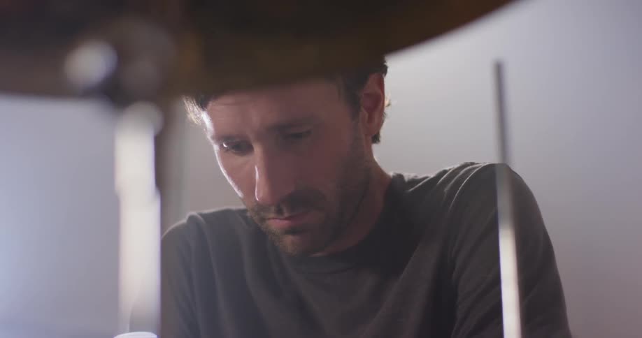 A man sits at a drum kit