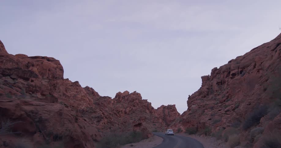 A vehicle travels up a hilly rural road