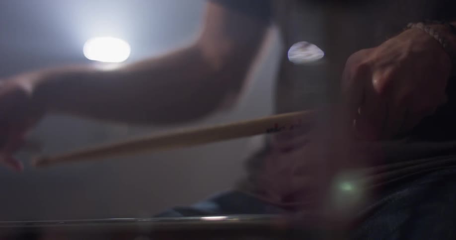Man hits the drum with drumsticks