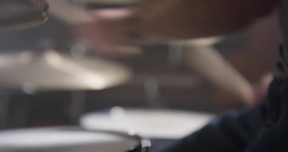 A man plays drums with drumsticks