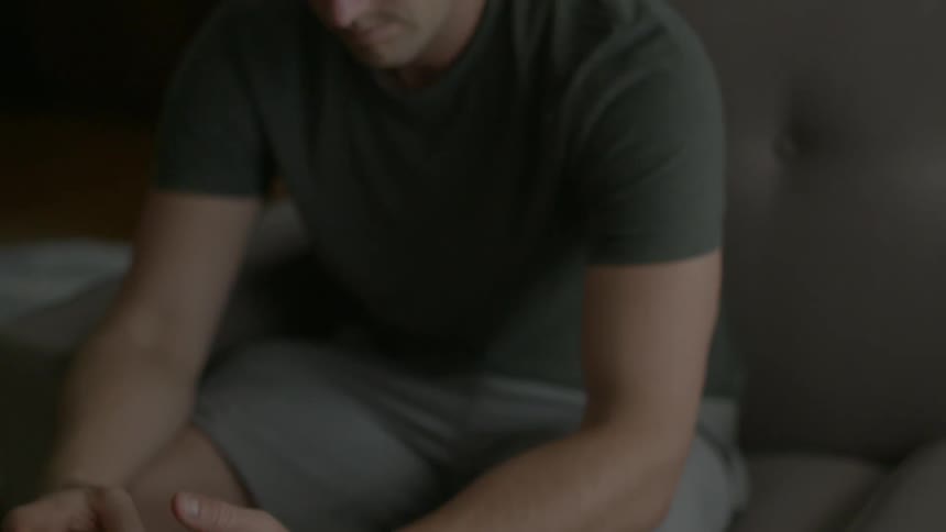 A man sits and reads his smartphone