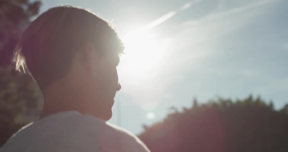 A man walks outside on a sunny day