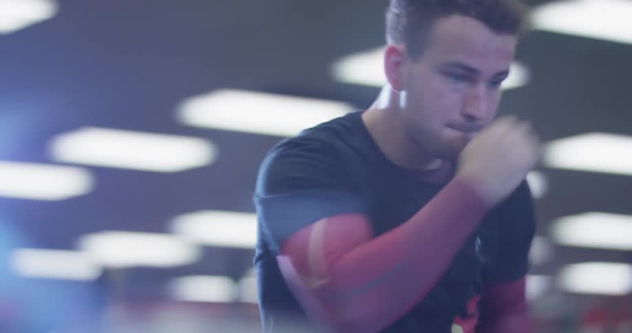 A man is shadowboxing in the gym