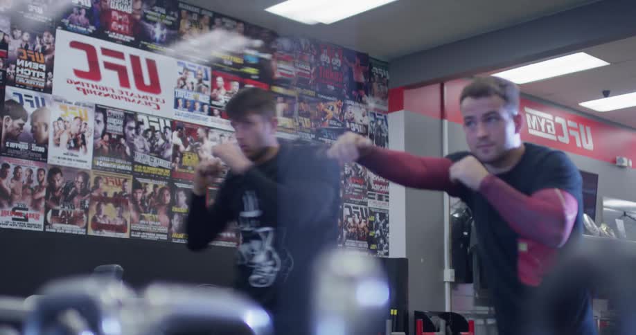 Two men train by throwing punches