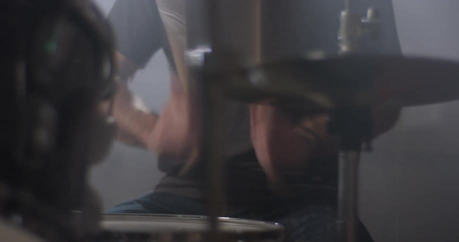 A man plays drums in a garage