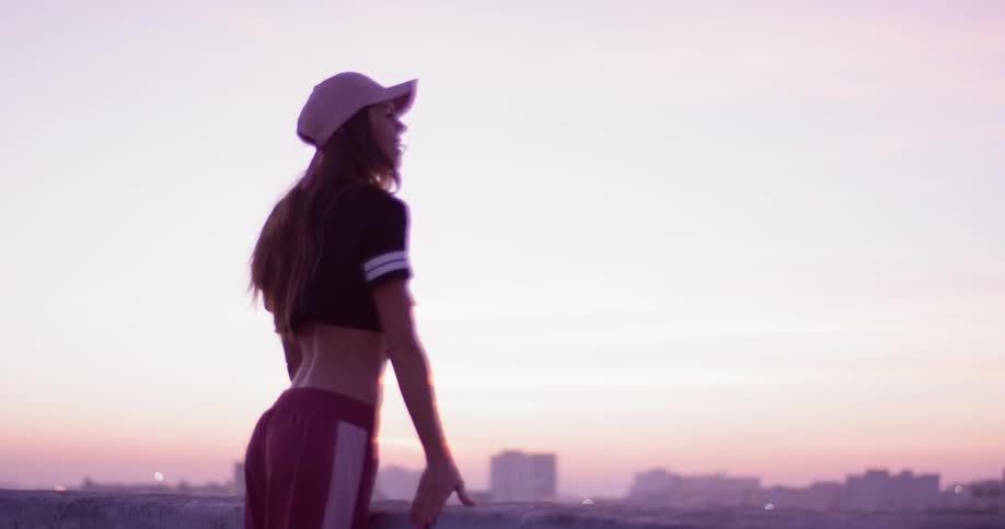 Woman leans on a ledge overlooking a city