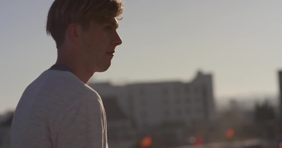 A man stands outside on a sunny day