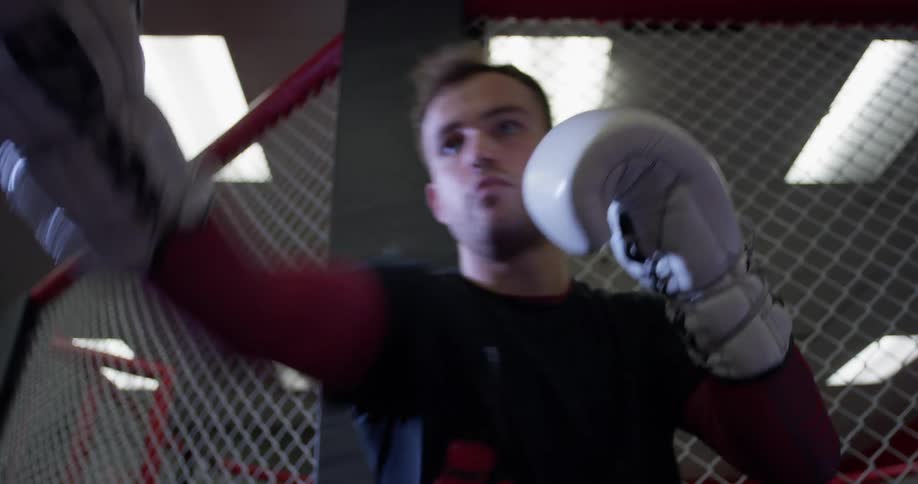 A boxer hits a punching bag at a gym
