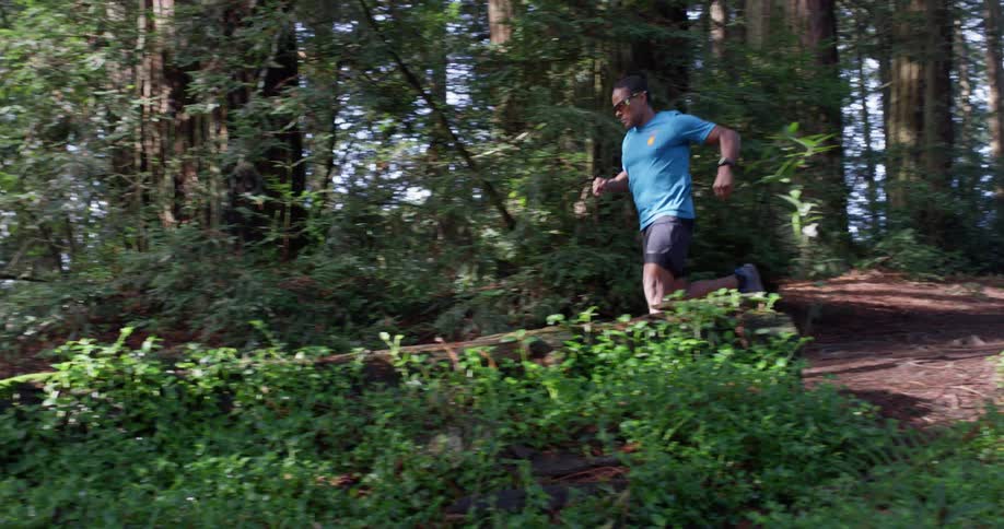 Man jogs on a path through the woods