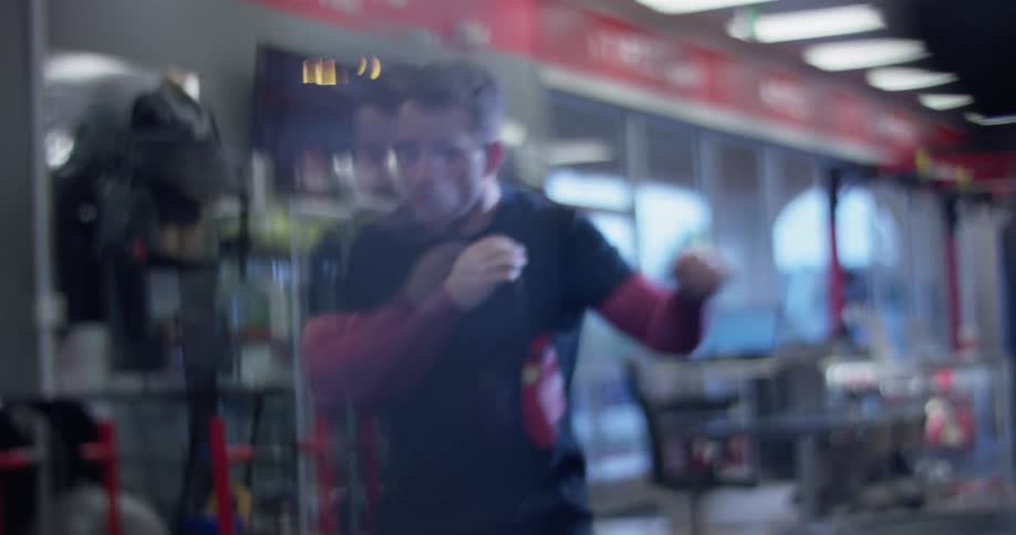 Man practices punching jabs in a gym