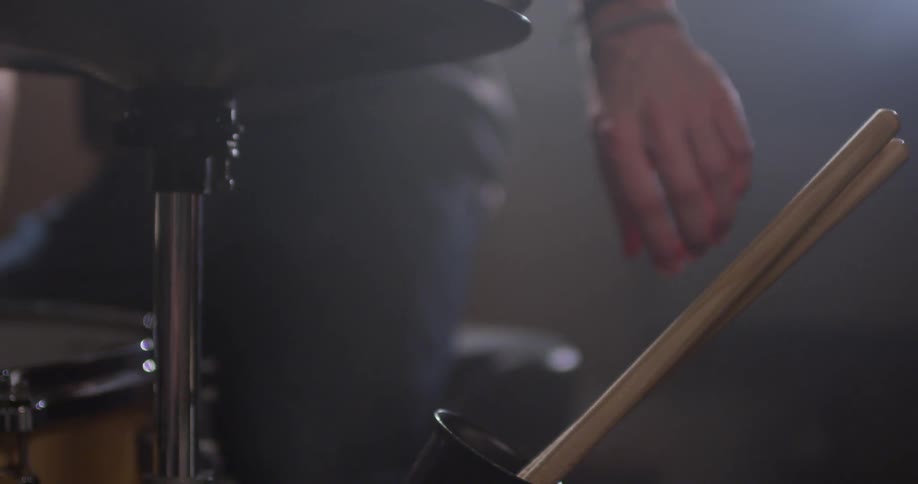 A man sits down at his drum kit