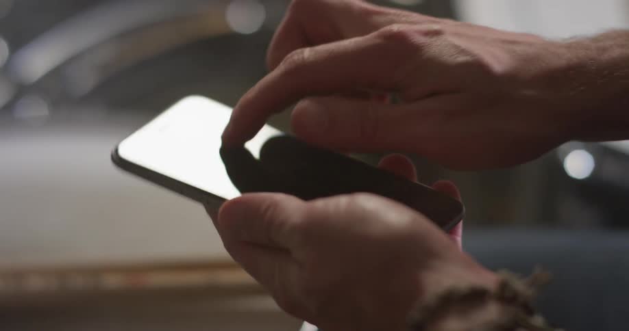 A man scrolls and types on a phone