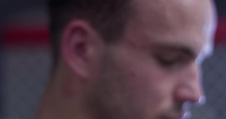 A man stands sweating inside an mma ring
