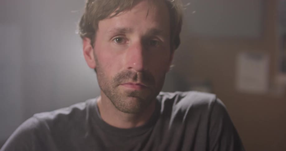 A man looks around and stands up