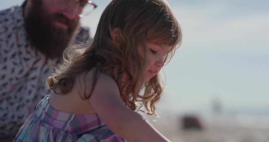A young girl plays in the sand on the beach