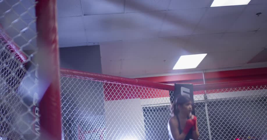 A boxer punches the air in a fighting ring