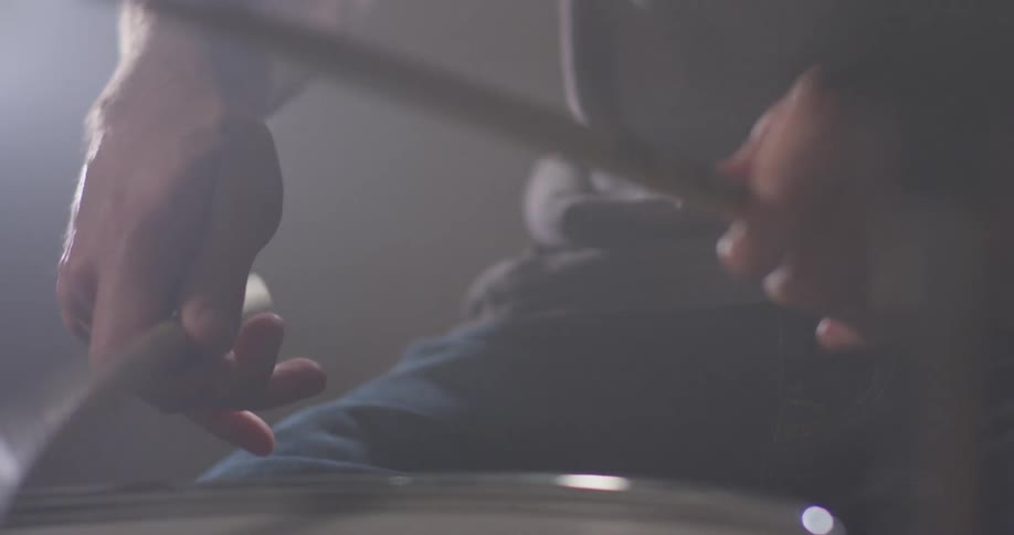A man plays drums with drumsticks