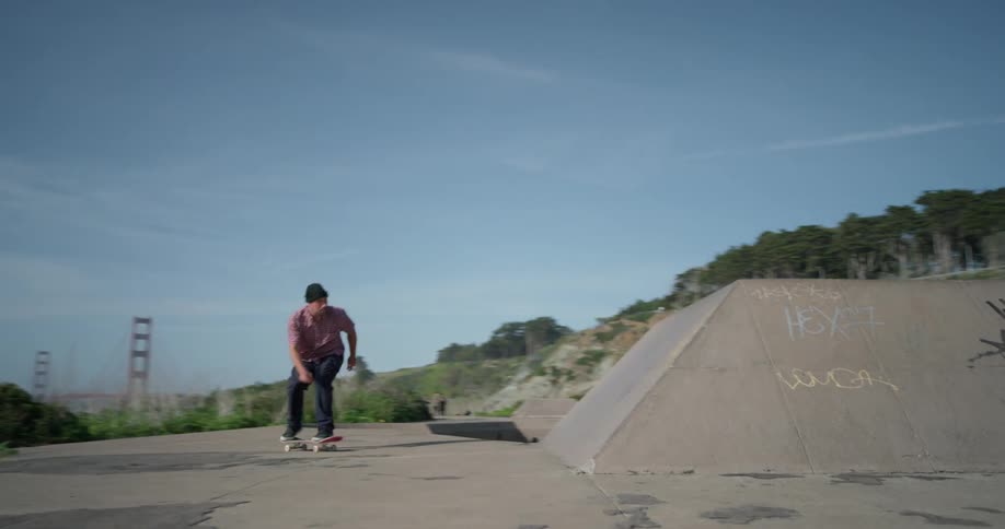 The man rides on his skateboard on a sunny day