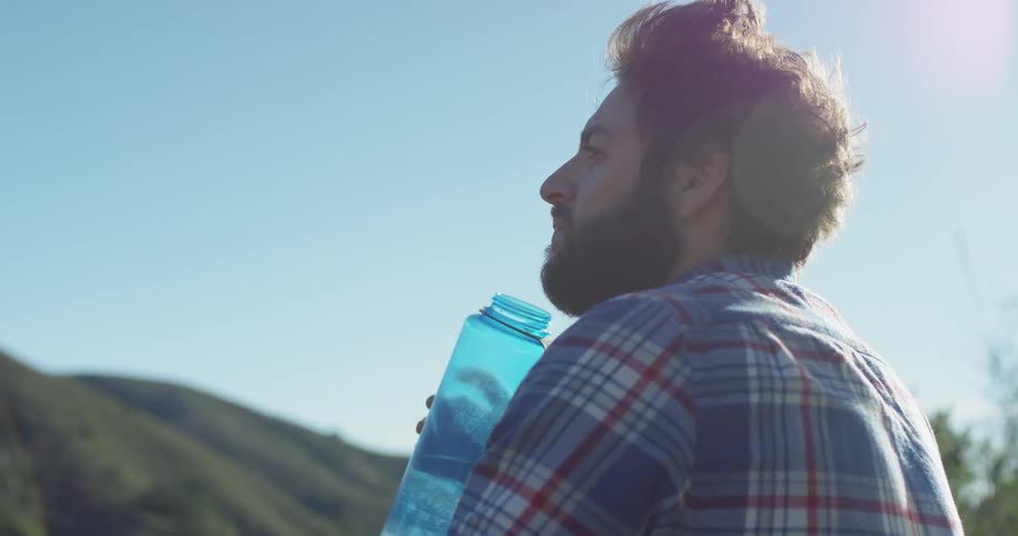 A hiker rests to drink water