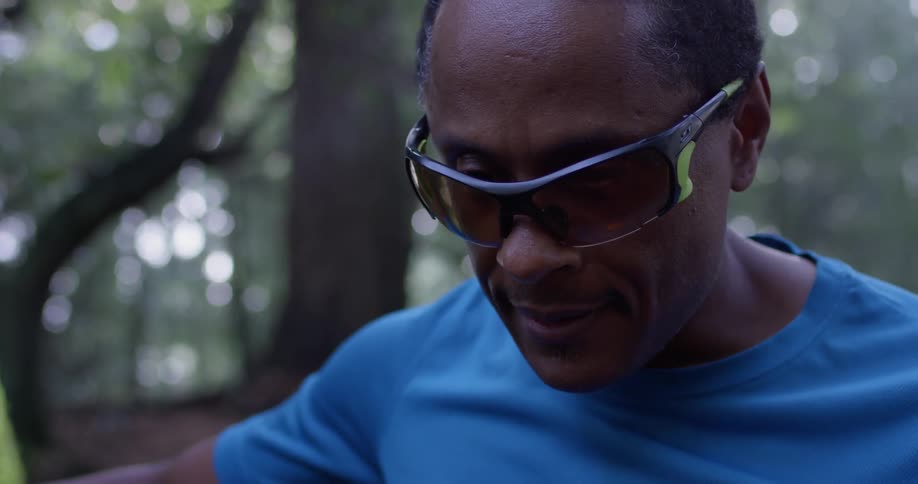 A man is wearing sunglasses in the woods