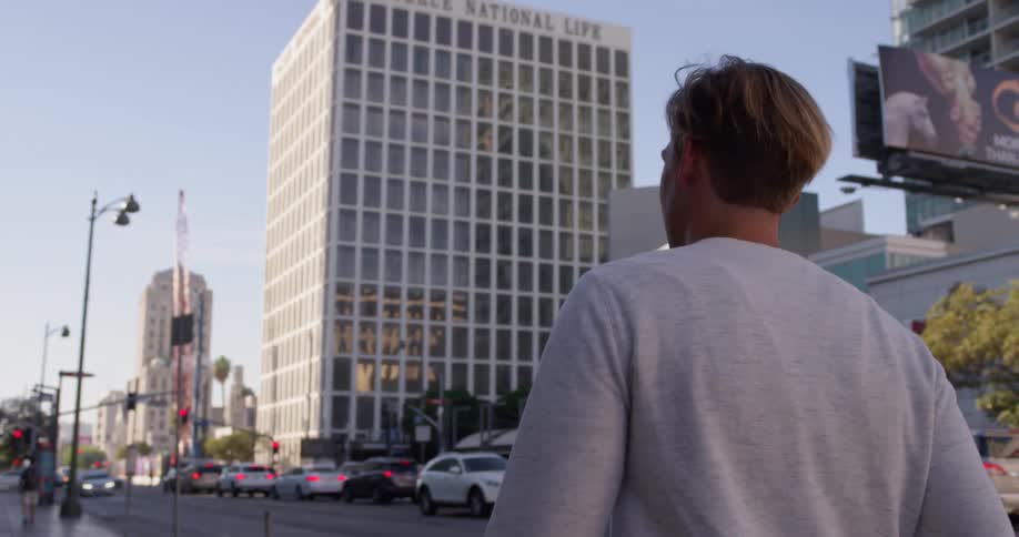 A man walks on a city sidewalk