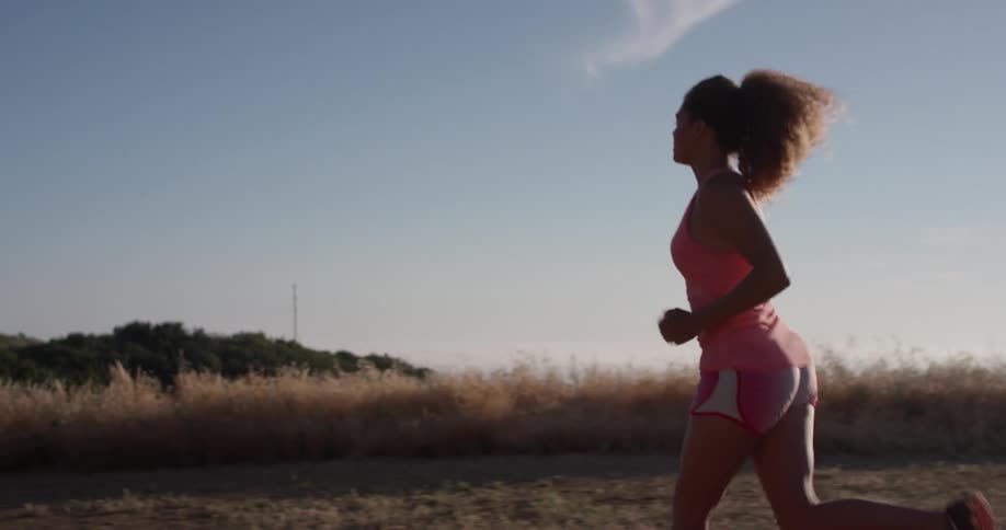 A woman jogs in a rural area on a sunny day