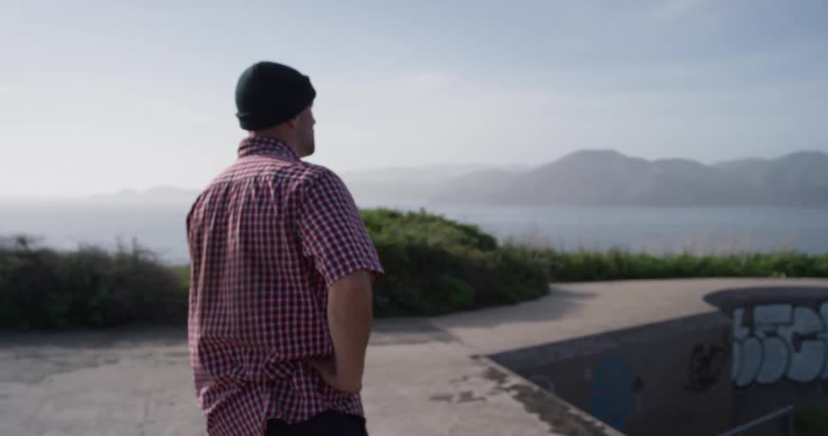 A man stands with his skateboard in a skate park