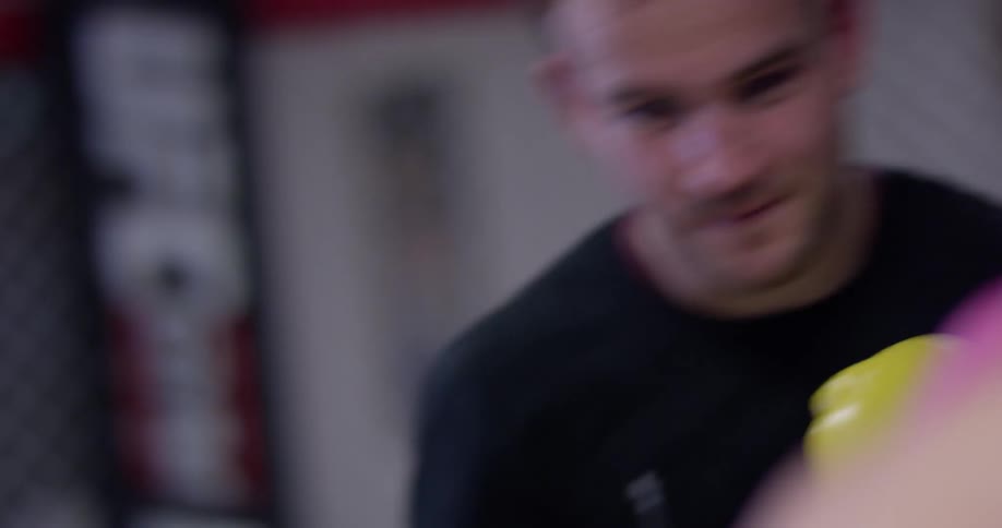 Two people train inside an mma ring