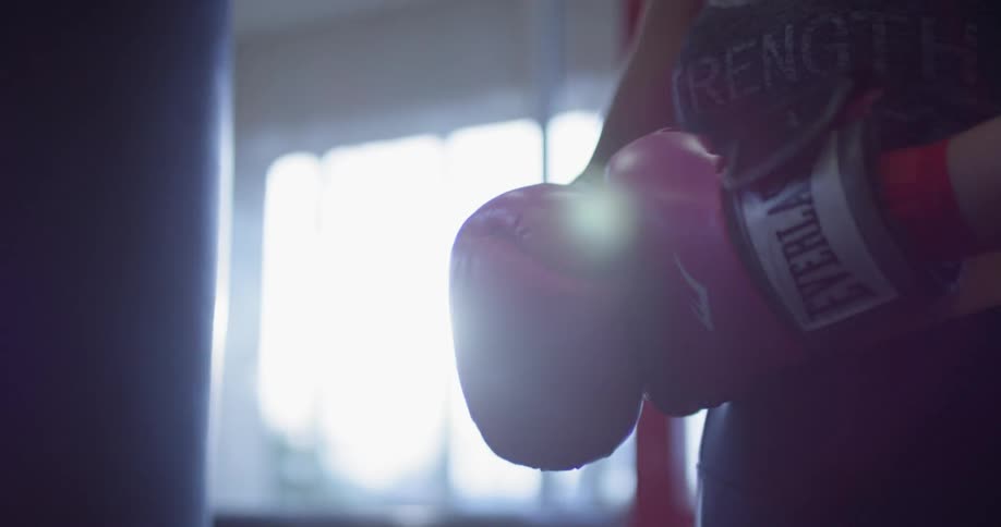 A woman puts on boxing gloves at the gym