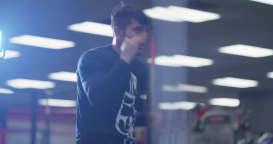 A boxer punches the air in a gym