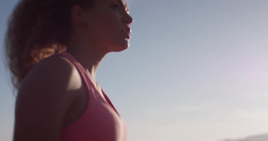 A woman hikes in a rural area on a sunny day