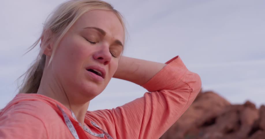 A woman breathes heavily in a desert