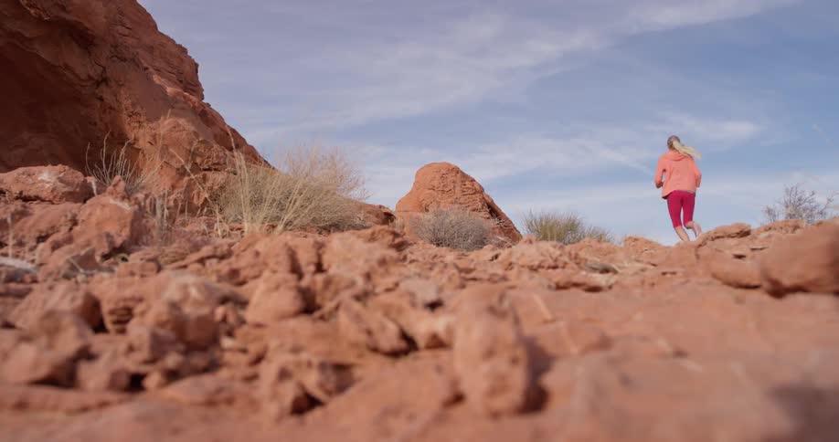 Woman jogs over rocky terrain