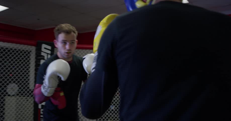 Two men train inside an mma ring
